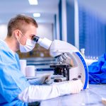 Scientist working in chemistry laboratory, examining samples at
