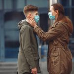 A boy and mother are wearing protective masks